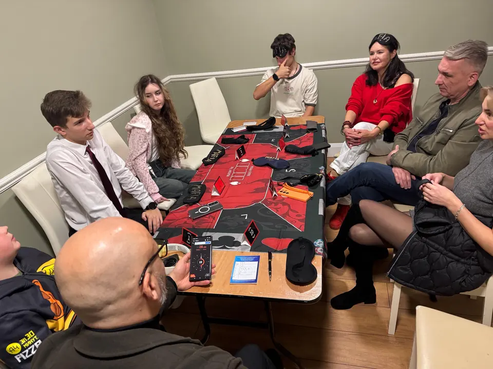 Players around a table with a red cloth in a small room