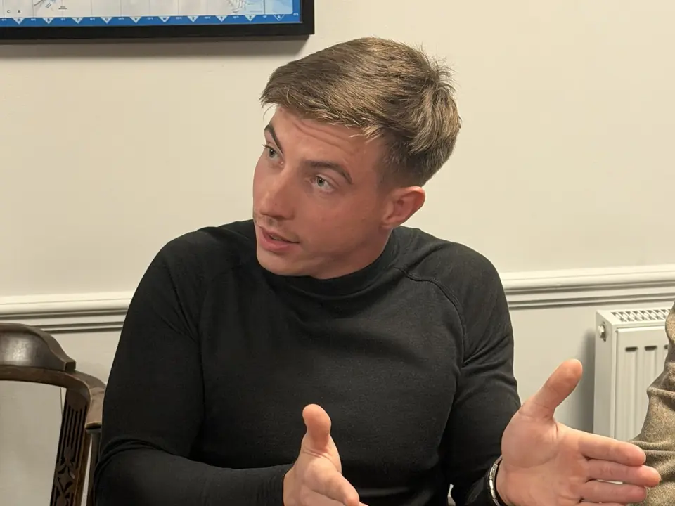A player at the table with a cup of tea during the discussion