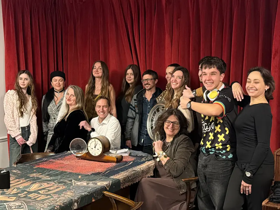A group photo of the guests of the 24 October evening in front of red curtains