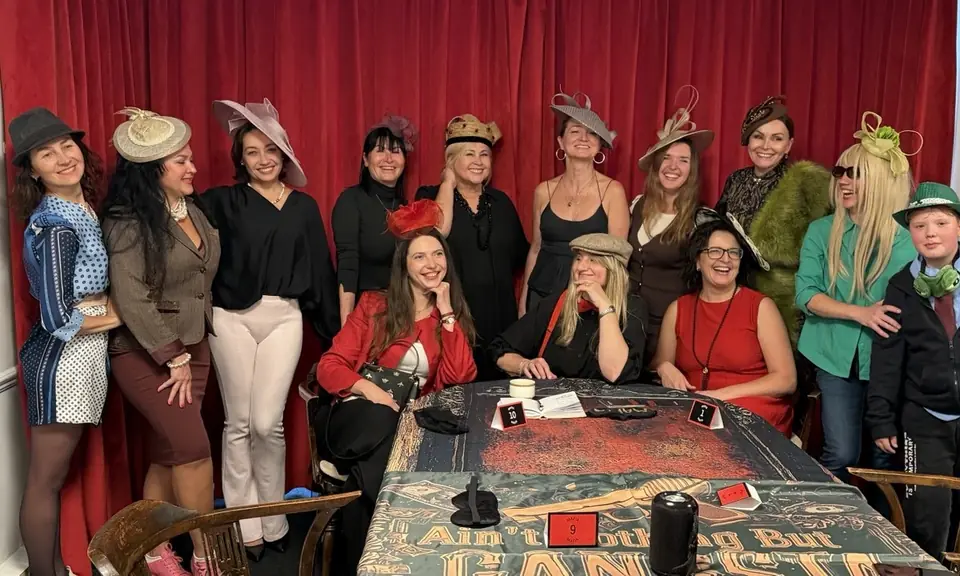 Fortuna Elite Club members and guests together in front of red velvet curtains